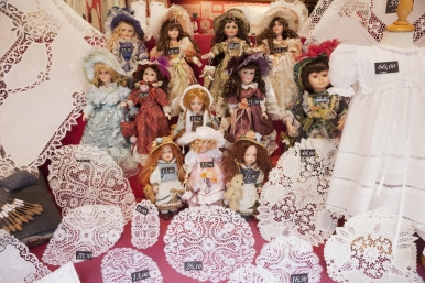 Belgian lace and dolls on display at a shop window
