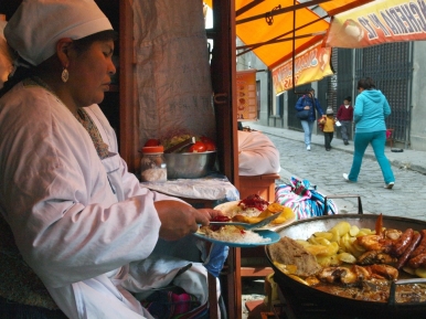 A woman serves fried meats at the silpancheria kiosks on Calle Jiminez
