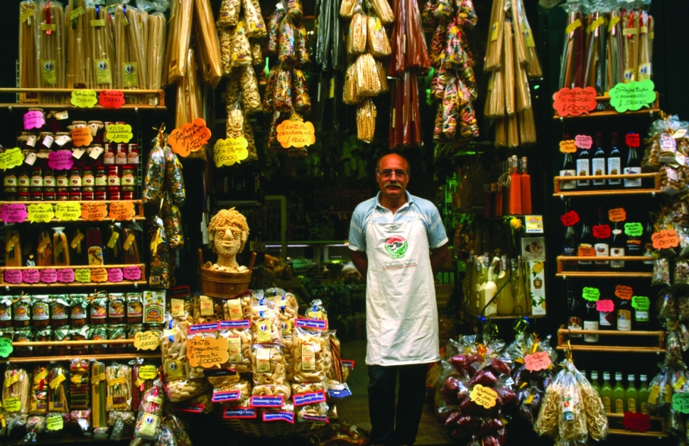 A vendor poses in front of his pasta shop