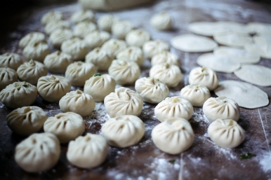 Boiled dumplings, usually with minced pork and chopped cabbage inside, are made by hand