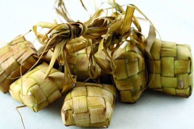 Ketupat cooked the traditional way in woven coconut leaf casing.
