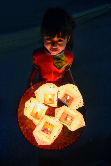 A young girl with candle lanterns on a full moon night