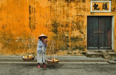 A fruit vendor stopping to pose for the camera
