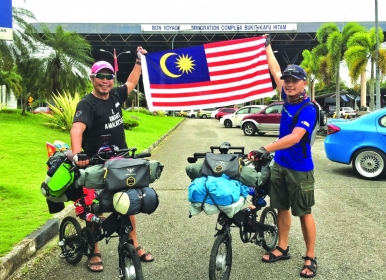 Wu (left) and Ving exiting Malaysia at the Bukit Kayu Hitam border town on 10 September last year