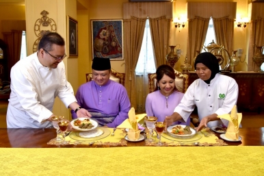 Tuanku Syed Faizuddin and Tuanku Hajah Lailatul Shahreen (centre) being served the kurma daging Perlis at Istana Arau, by palace chef Sobiah Bidin (right) and Malaysia Airlines food and beverage senior manager Fazal Mahbob (far left)