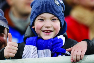 A young fan gives the thumbs up during a match