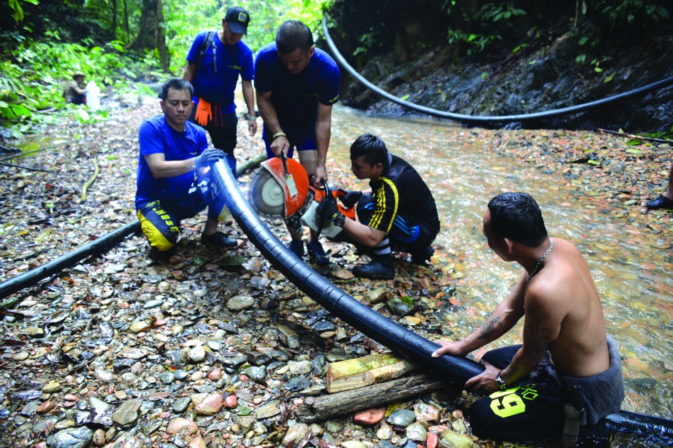 Installing a water pipe in one of the villages in Sarawak. Credit: Helping Hands Penan