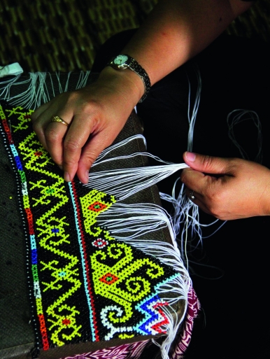 Penan women at Long Iman make beaded crafts for sale to tourists