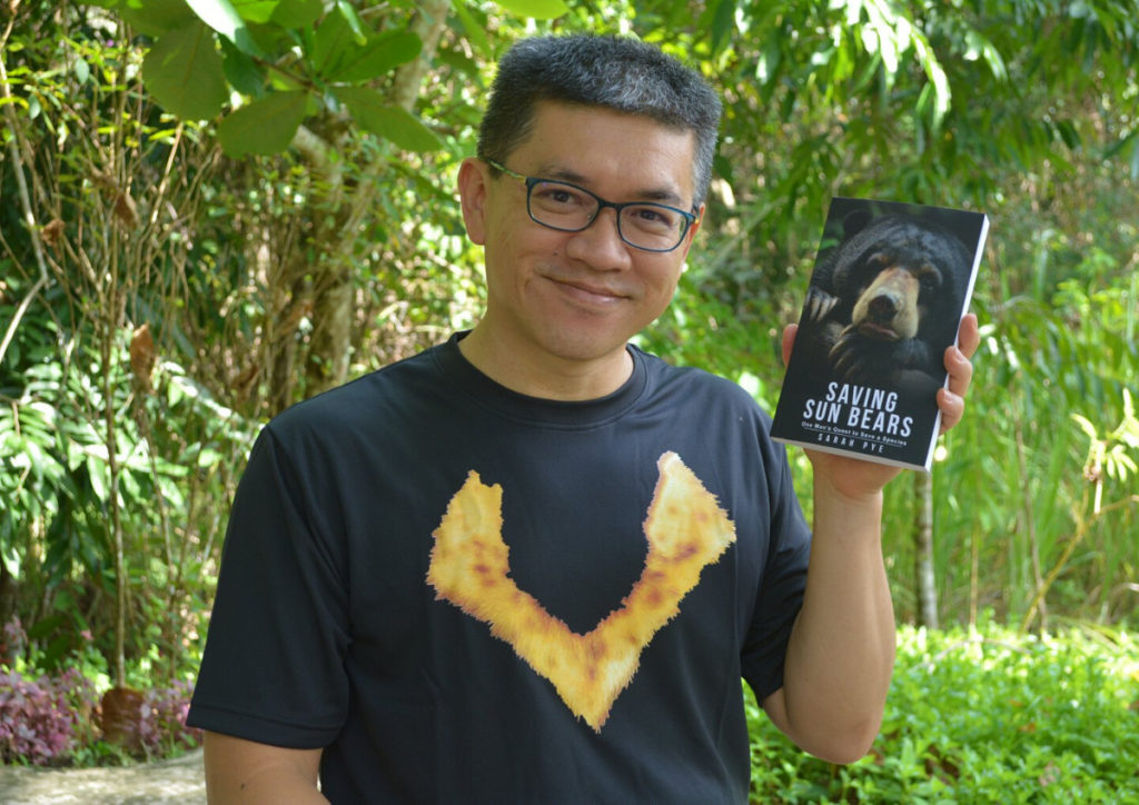 Dr. Wong with a copy of "Saving Sun Bears"