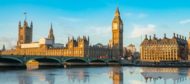 Big Ben and Westminster Parliament with blue sky and water reflection